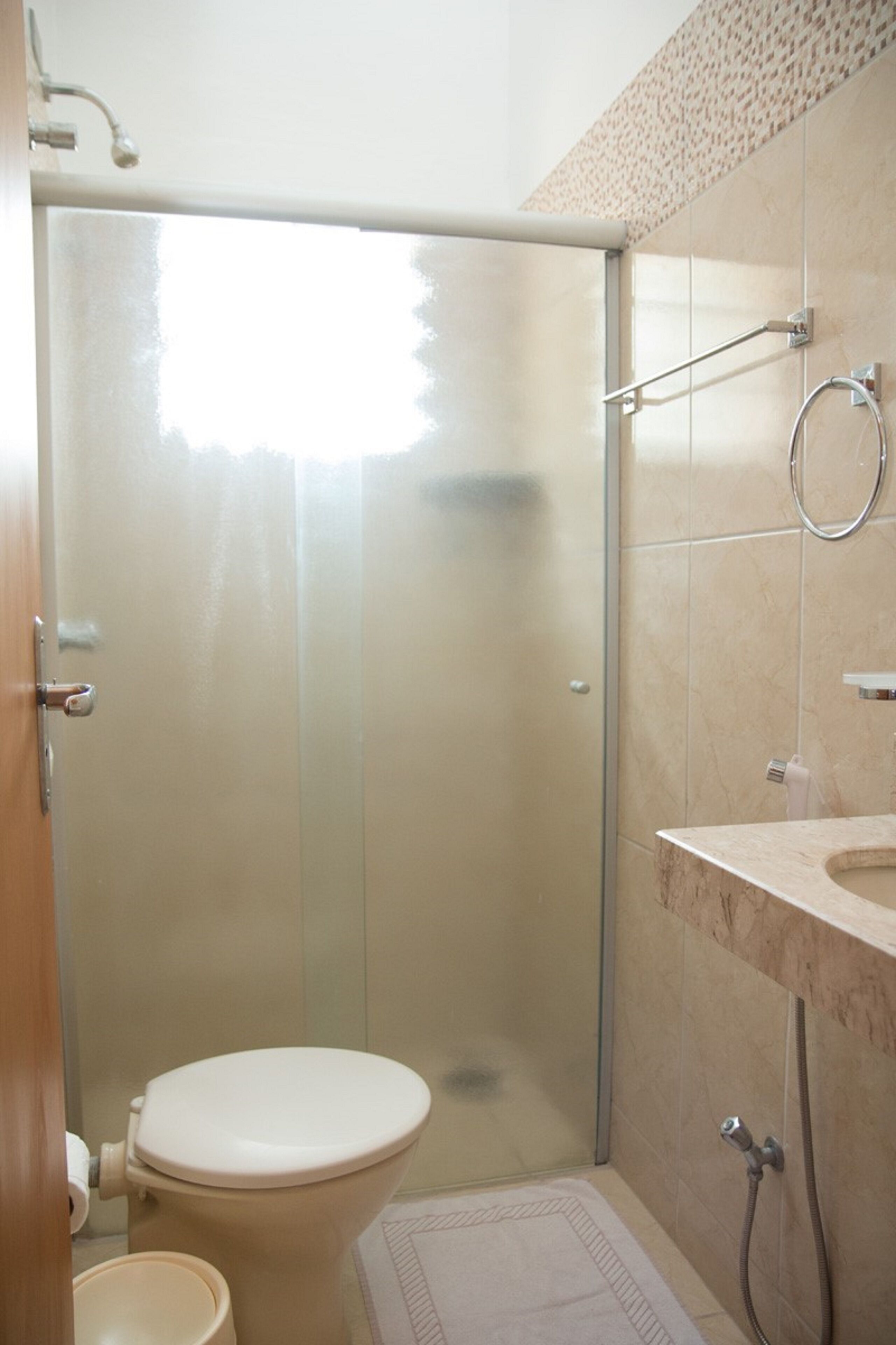 Un baño con inodoro, ducha y lavamanos.