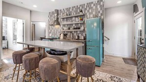 A modern kitchen with a central island, bar stools, a teal refrigerator, and patterned backsplash. - Downtown Private Backyard Oasis 5 min to Broadway (Nashville)