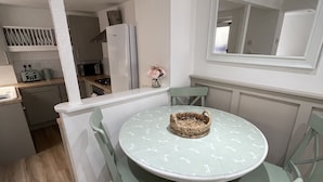 A compact kitchen with a dining area featuring a round table and matching chairs.