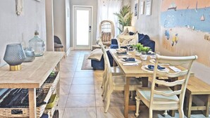 Comedor con mesa de madera dispuesta para cuatro personas, rodeada de sillas.