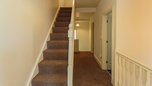A staircase with carpeted steps and a white balustrade. - Cherry Property - Coconut Suite (Blackpool)