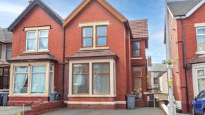 A red brick house with two bay windows and a small porch. - Cherry Property - Coconut Suite (Blackpool)