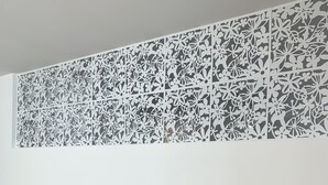 A wall with a decorative panel featuring intricate floral patterns.