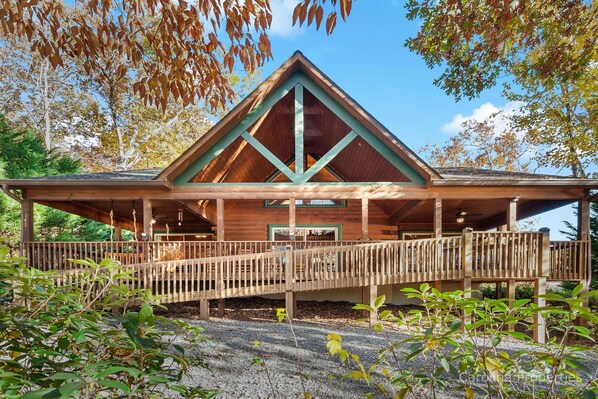 Eine Holzhütte mit einer Veranda und einer Holzbrücke, die zum Eingang führt.