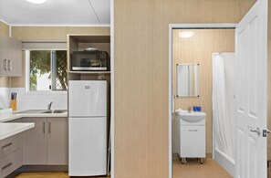 A modern kitchen with a refrigerator, microwave, and sink. - Discovery Parks - Ayr (Ayr)