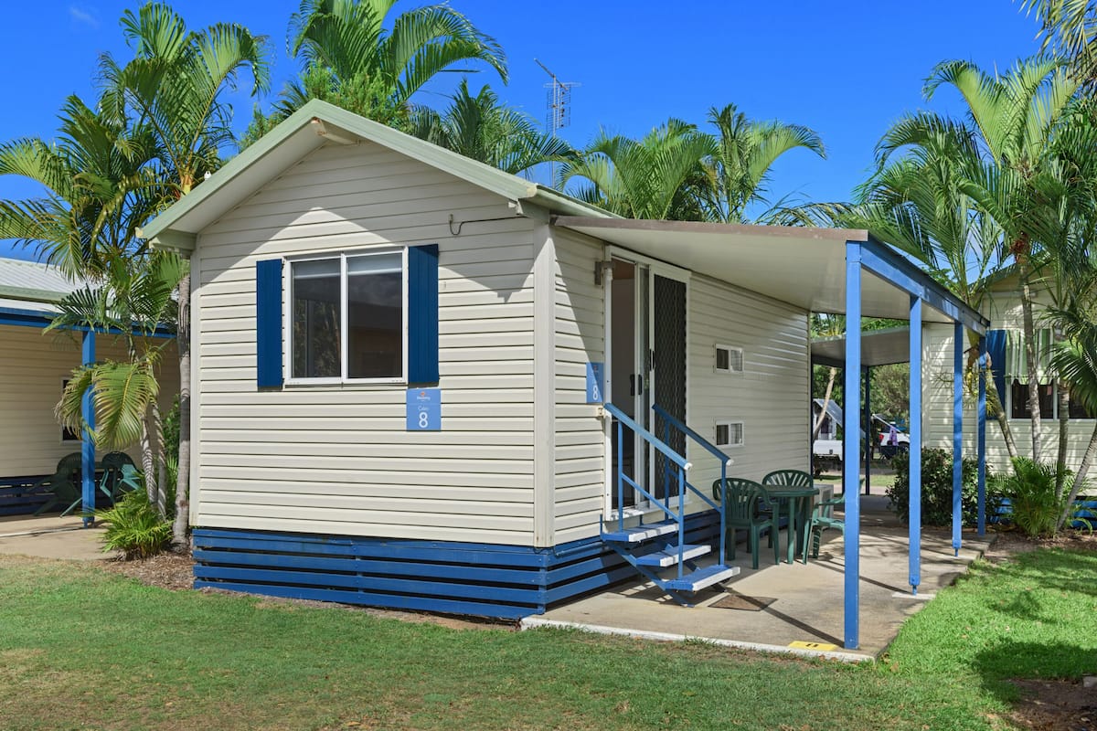 A small, single-story building with a covered porch and a small patio area.