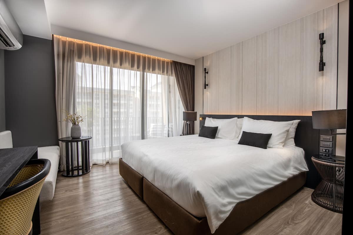 Ein modernes Hotelzimmer mit einem großen Bett, einem Schreibtisch und einem Sessel.