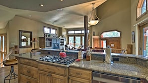 A spacious kitchen with granite countertops, wooden cabinets, and a red kettle. - Steps to Gondola! Hot Tub Haven in Breckenridge (Breckenridge)