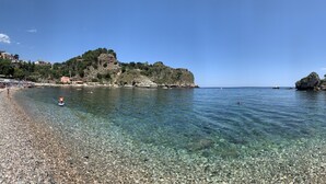 A clear beach with pebbles, calm water, and rocky cliffs. - SUN SEA HOUSE TAORMINA  (Giardini Naxos)