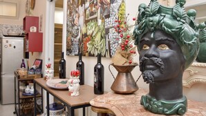 A kitchen with a marble countertop, a decorative bust, and various kitchen items. - SUN SEA HOUSE TAORMINA  (Giardini Naxos)
