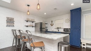 A kitchen with a central island, stainless steel appliances, and a blue cabinet. - ❤️ Wide Open Water!  Huge Boat Dock w/ rope swing!  Lake toys (Kayak, Paddleboard, Lily Pad) included!  Great fishing!  🐟 (Gun Barrel City)