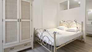 Ein Schlafzimmer mit Bett, Kleiderschrank und Spiegel.