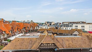 Una plaza histórica con edificios tradicionales de entramado y cielo despejado.
