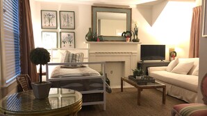 A cozy living room with a bed, a sofa, a TV, and a fireplace. - Convenient quiet LSU Location near City Park, coffee shops, restaurants and bars (Baton Rouge)