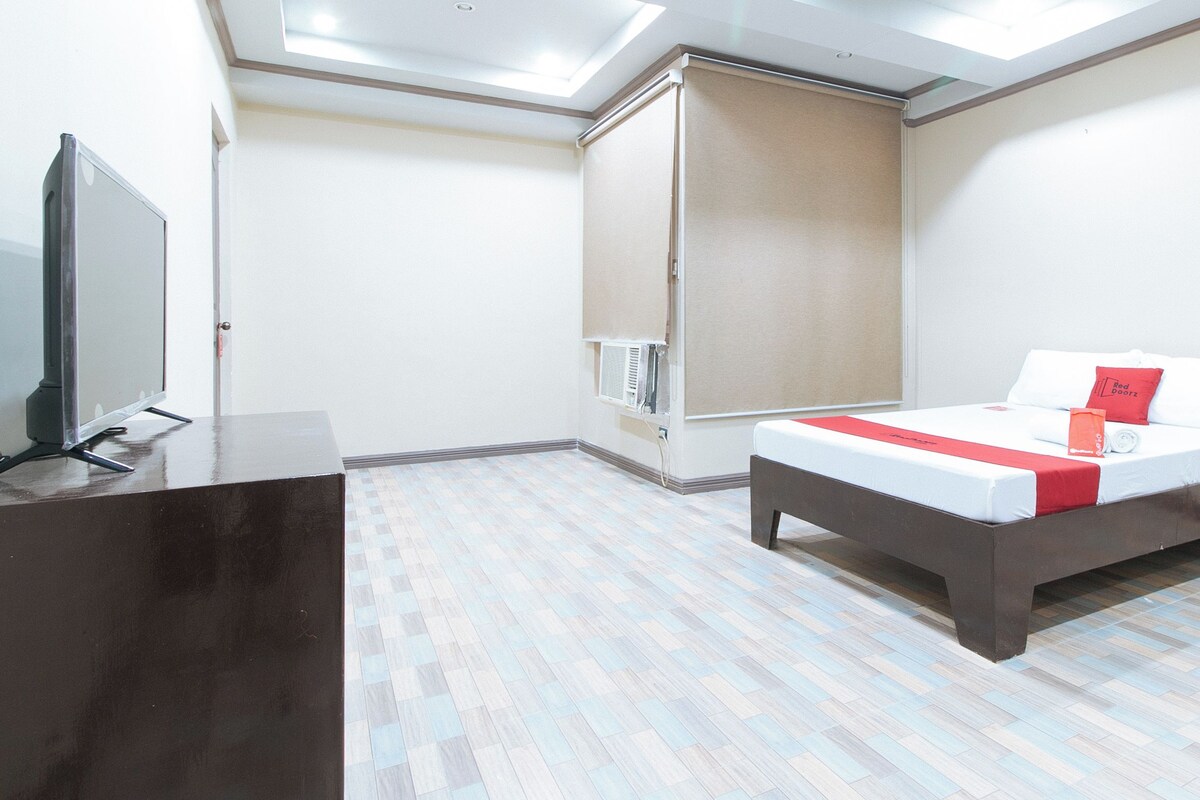 A hotel room with a bed, a TV, and a wardrobe.