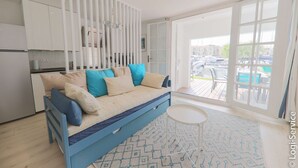 Une chambre moderne avec un canapé-lit, une petite table et un tapis à motifs.
