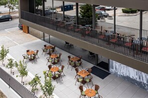Terraza en la azotea con asientos exteriores y vistas a coches estacionados.