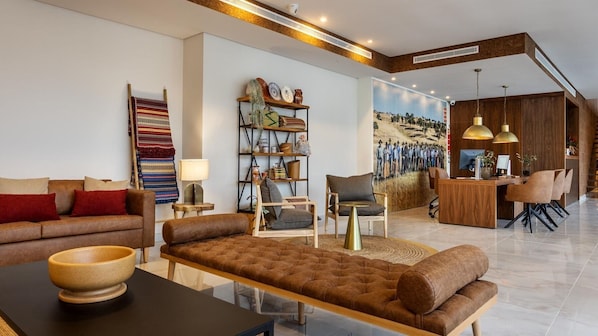 Una sala de estar moderna con un sofá, sillones, una mesa de centro y una estantería.