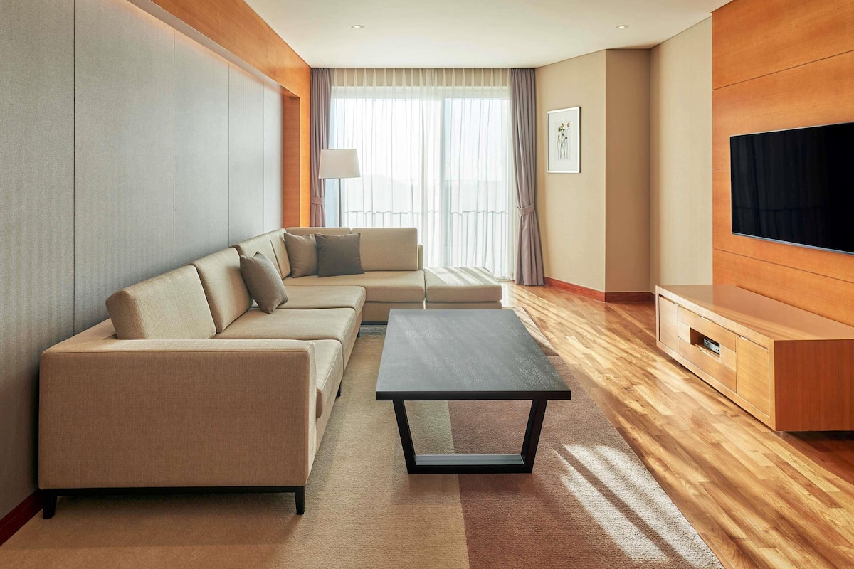 Una sala de estar moderna con un sofá, una mesita de centro, un televisor y un mueble de madera.