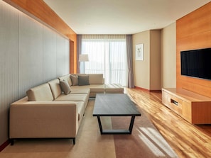 A modern living room with a sofa, a coffee table, a TV, and a wooden cabinet.
