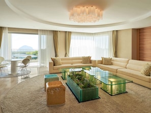A modern living room with a sofa set, glass coffee table, and a view of the outdoors.