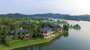 Una propiedad junto al lago con varias casas, una orilla sinuosa y colinas al fondo.