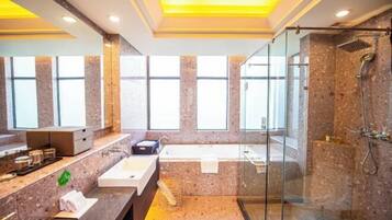 Un baño moderno con ducha envuelta en vidrio, una bañera y un tocador con lavamanos.