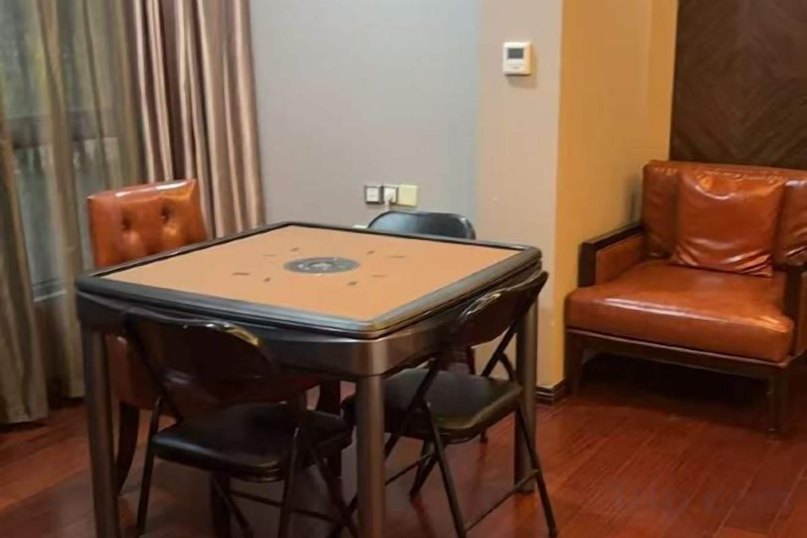 A room with a table and chairs, a sofa, and a window with curtains.