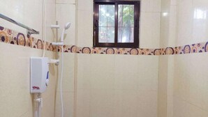 A bathroom with a shower, a window, and a towel rack. - Reddoorz @ Garcia Hernandez Bohol (Garcia Hernandez)