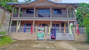 A two-story building with a flat roof and a central entrance. - Reddoorz @ Garcia Hernandez Bohol (Garcia Hernandez)