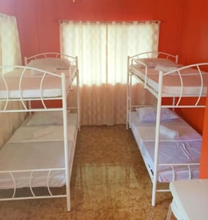 A room with bunk beds, a window with curtains, and a carpeted floor. - Reddoorz @ Garcia Hernandez Bohol (Garcia Hernandez)