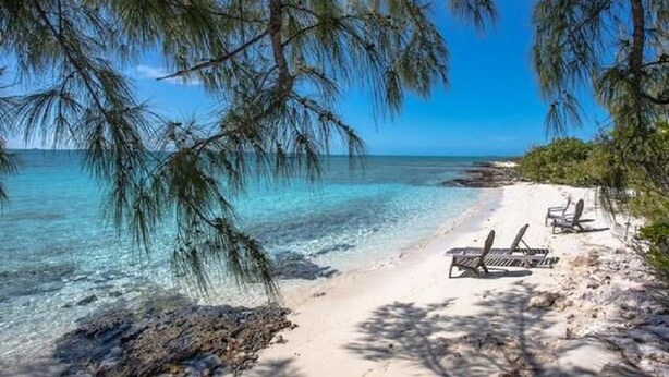 Una playa cerca, sillas reclinables de playa, toallas de playa