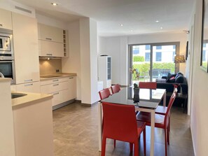 Enjoy meals in the spacious kitchen with oven and microwave, adjacent to a dining area with a large table and comfortable seating.