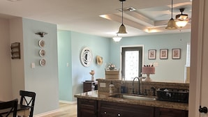 A spacious kitchen with a large island, wooden cabinets, and a dining area with a table and chairs. - whole 3 bedroom home (Eagle Pass)
