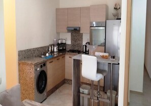 Enjoy cooking in this fully equipped kitchen with a gas stove, washing machine, and refrigerator.