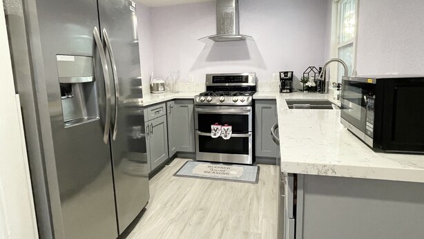 A modern kitchen with stainless steel appliances, a built-in oven, and a microwave. - Entire Newly Renovated House in North Pomona (Pomona)