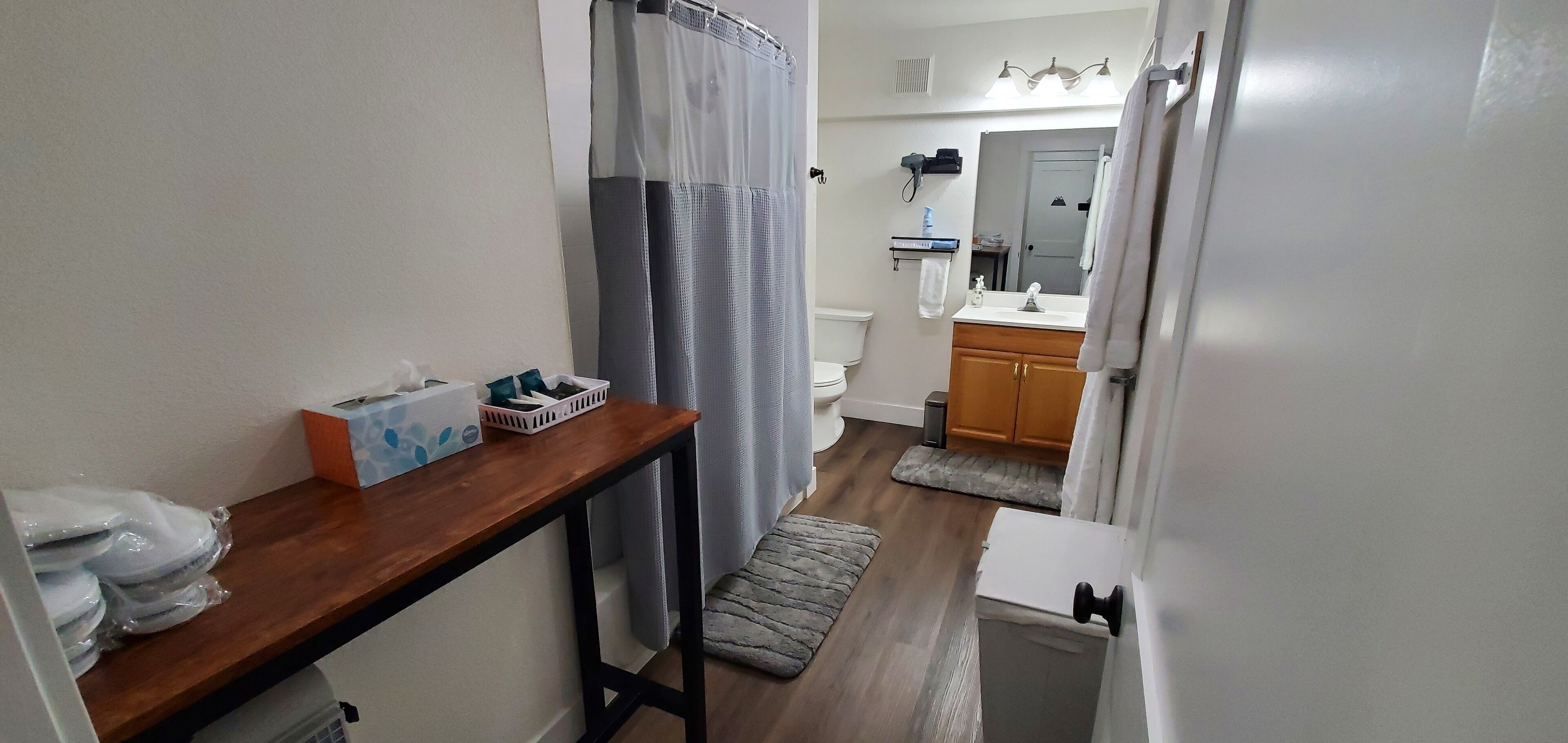Une petite salle de bain avec un meuble-lavabo en bois, des toilettes et un espace douche.