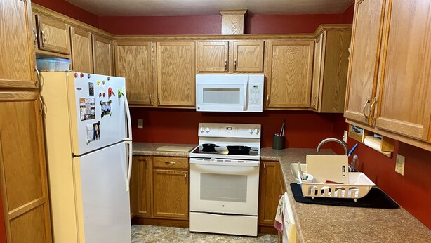 A kitchen with wooden cabinets, a refrigerator, a microwave, an oven, and a sink. - 3 bedroom private vacation home in sundance (Sundance)