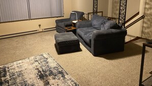 A living room with a sectional sofa, ottoman, and a patterned rug. - 3 bedroom private vacation home in sundance (Sundance)