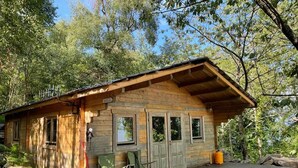 A rustic cabin with a wooden exterior, a porch, and a small deck.