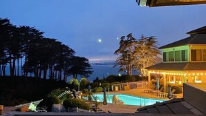 Un espace piscine avec vue sur l’océan et un bâtiment doté d’un toit végétalisé.