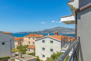 Zona residencial con edificios, un balcón y vistas al mar y a las montañas.