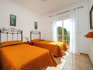 A bedroom with two beds, a balcony, and a view of greenery. - Solpadel by Interhome (Calpe/Calp)