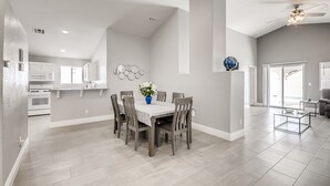 A spacious living room with a dining area, a kitchen, and a ceiling fan. - The Best House With A Heated Pool, Spa, and Safe, Sleeps 6 Comfortably (North Las Vegas)