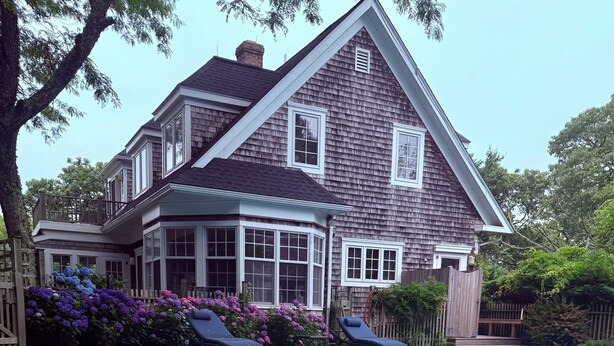 Une maison à deux étages avec une piscine, un patio couvert et une cour arrière clôturée.