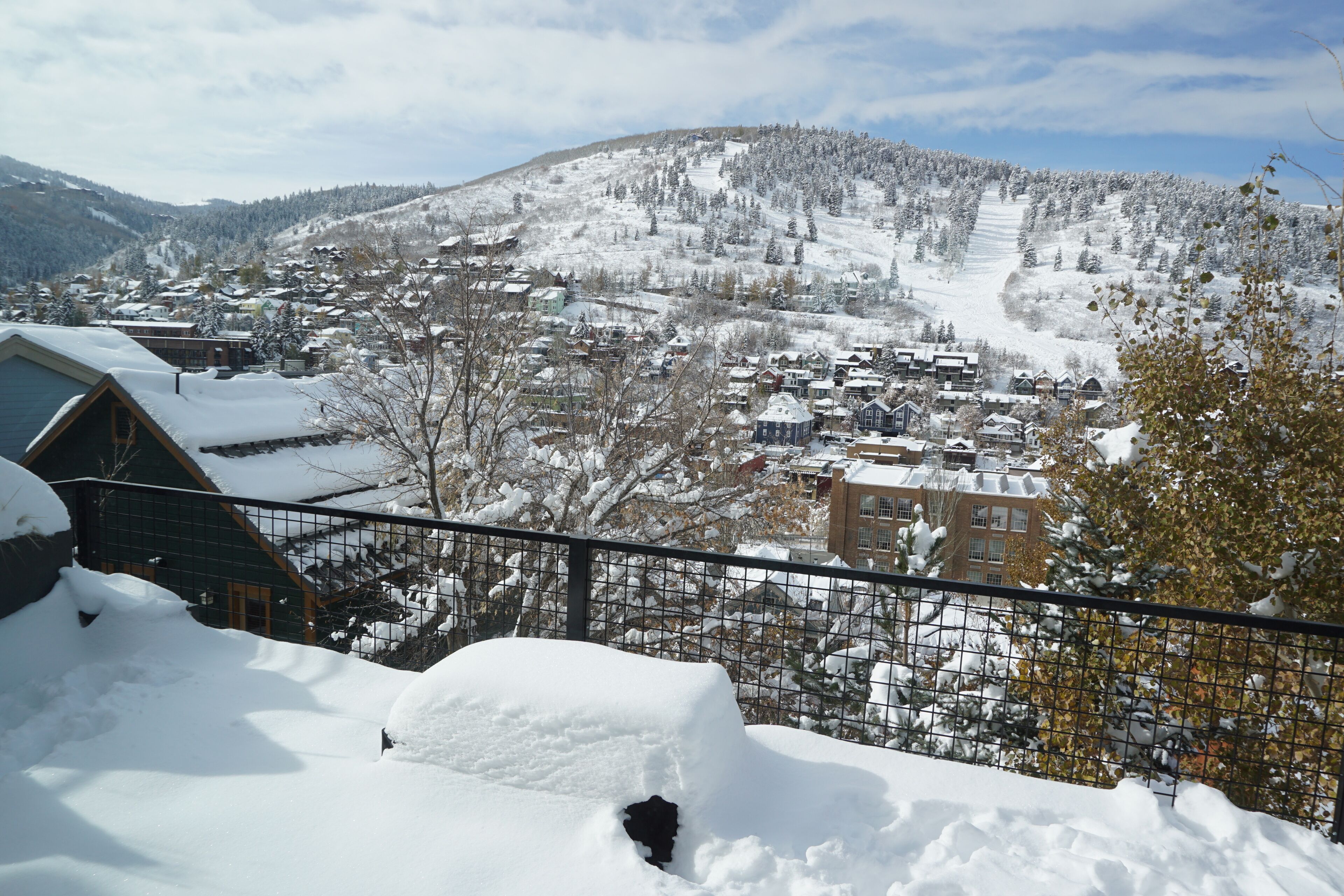 A snow-covered mountain town with buildings and a ski slope.