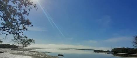 Un lago tranquilo con cielo despejado y reflejos de luz solar en el agua.