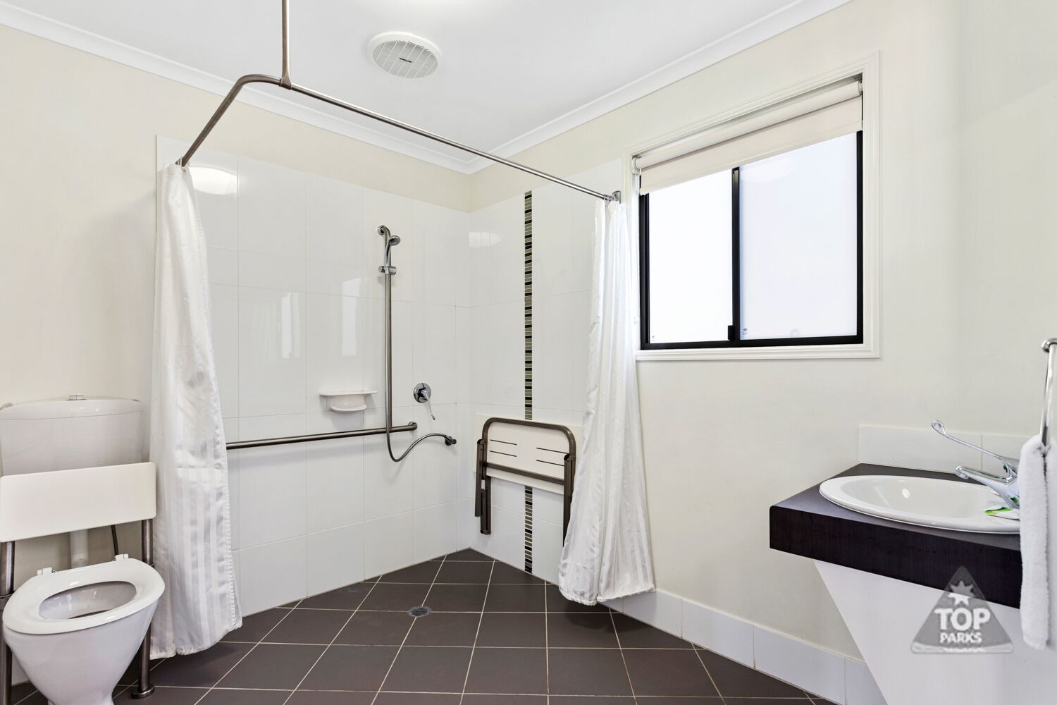 A bathroom with a shower, toilet, and sink.