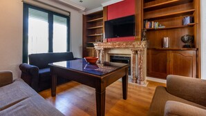 A living room with a fireplace, a television, and a bookshelf. - Air-Conditioned Villa "Mascota Rincón de la Victoria" with Pool, Garden & Wi-Fi (Rincón de la Victoria)