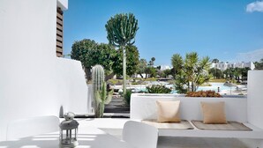 A white outdoor seating area with a table, cushions, and a lantern. - Studio Calimar Los Molinos with Pool, Wi-Fi & Terrace (Costa Teguise)